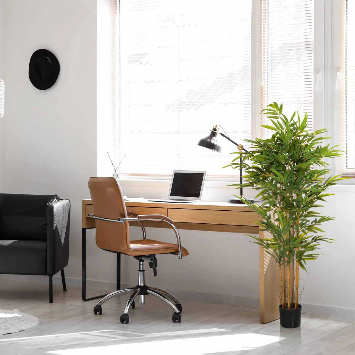 Grüne Kunstpflanze BAMBUS II in einem schwarzen Top im Homeoffice von hjh OFFICE