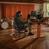Bürostuhl LiberNovo Maxis Airflow in Graphit an einem höhenverstellbaren Schreibtisch in einem Musikstudio von Libernovo