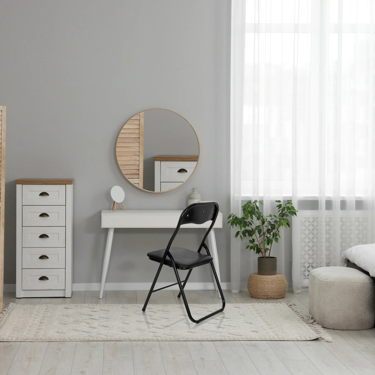 Schwarzer Klappstuhl TUDELA BASIC aus PVC in einem hellen Raum vor einem weißen Tisch von hjh OFFICE