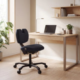 Kniehocker EvoShift in Schwarz an einem hellen Holzschreibtisch von hjh OFFICE